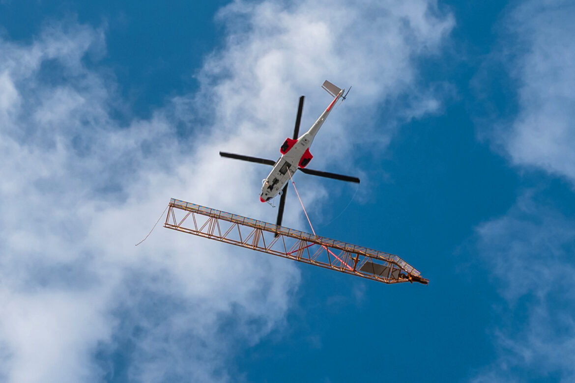À La Défense, une grue Liebherr prend l’hélicoptère pour rejoindre son chantier à 100 mètres de haut !